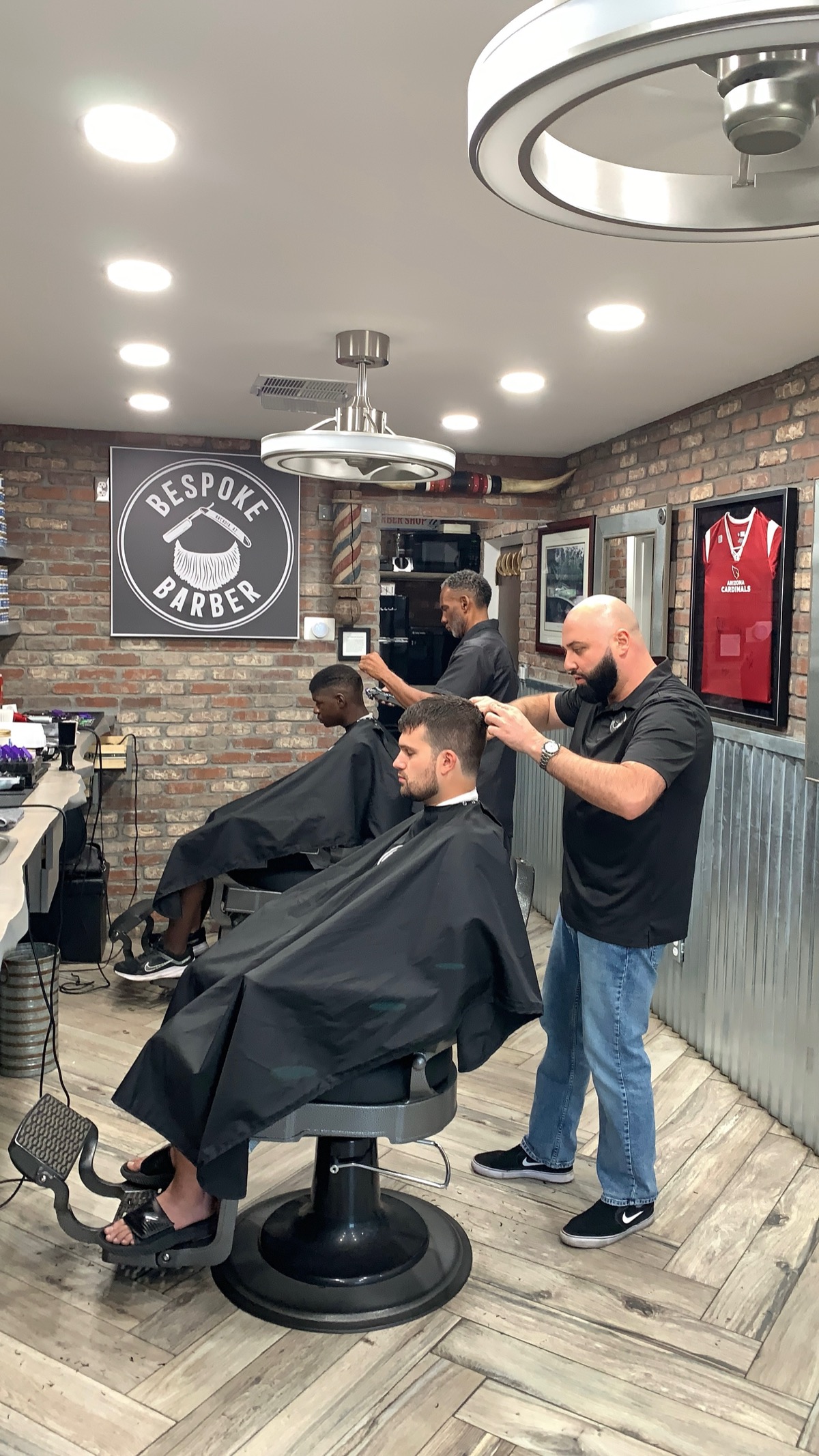 Two barbers cutting hair with great energy at Bespoke Barber