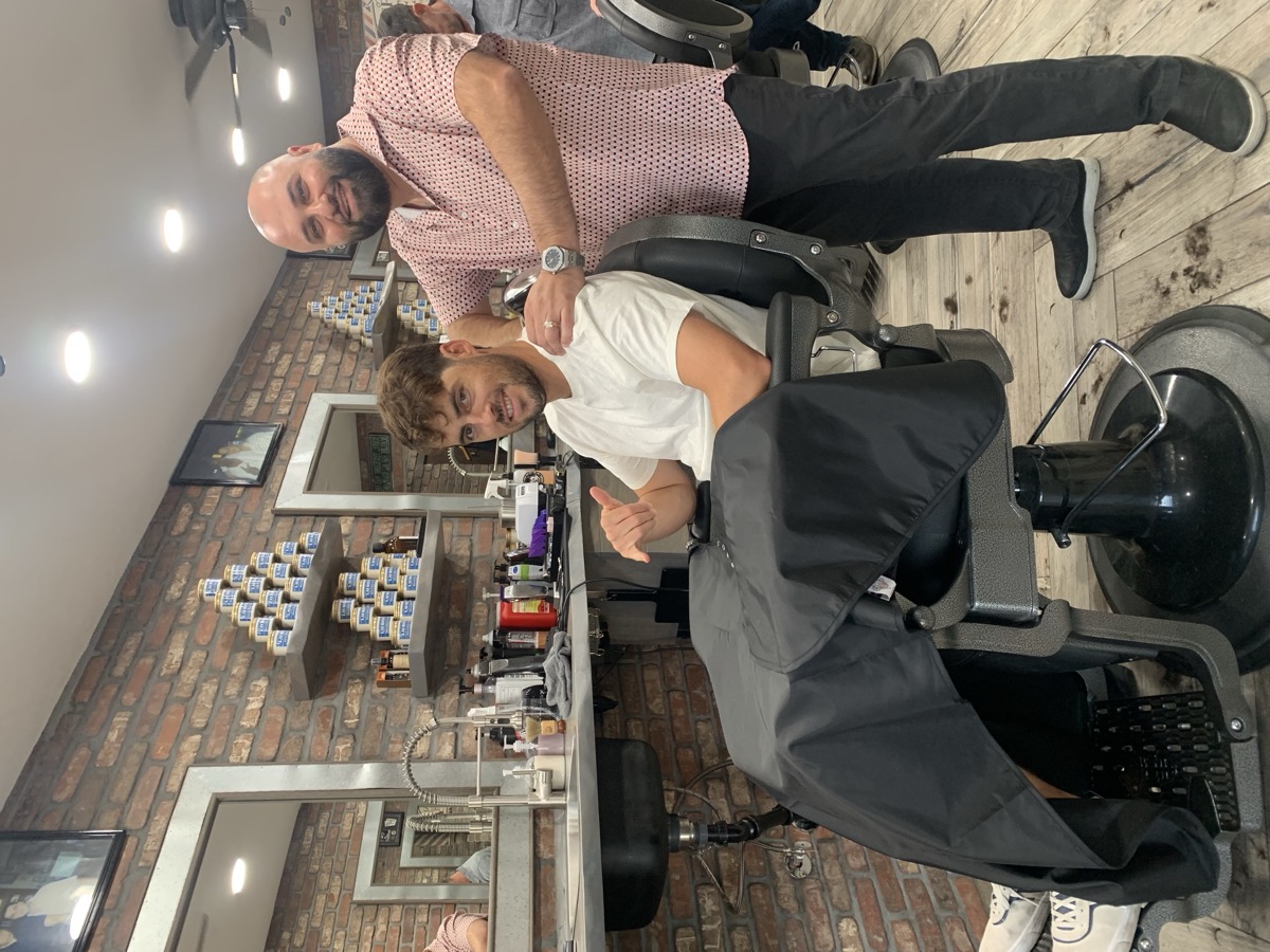 Happy client posing with Boris after a fresh cut at Bespoke Barber