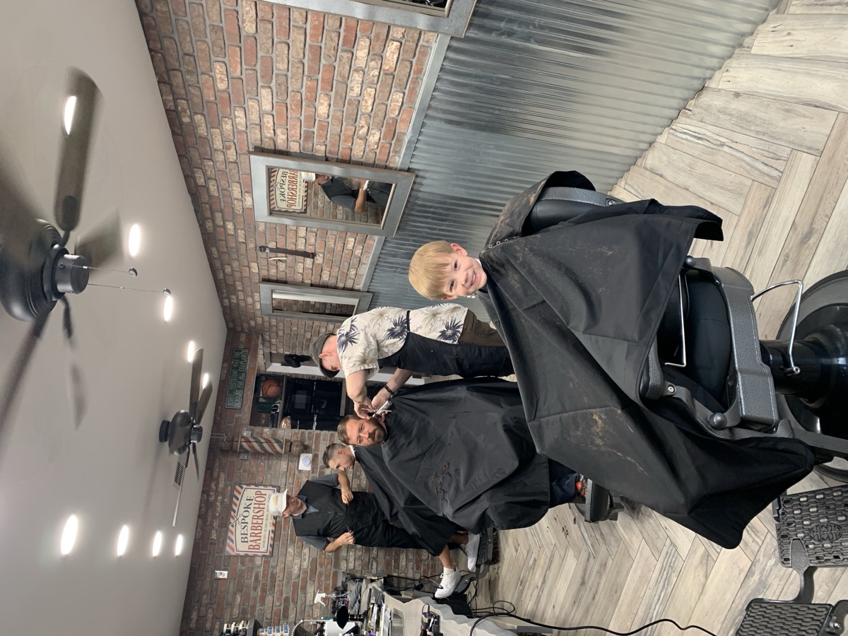 Kid smiling after a fresh haircut at Bespoke Barber