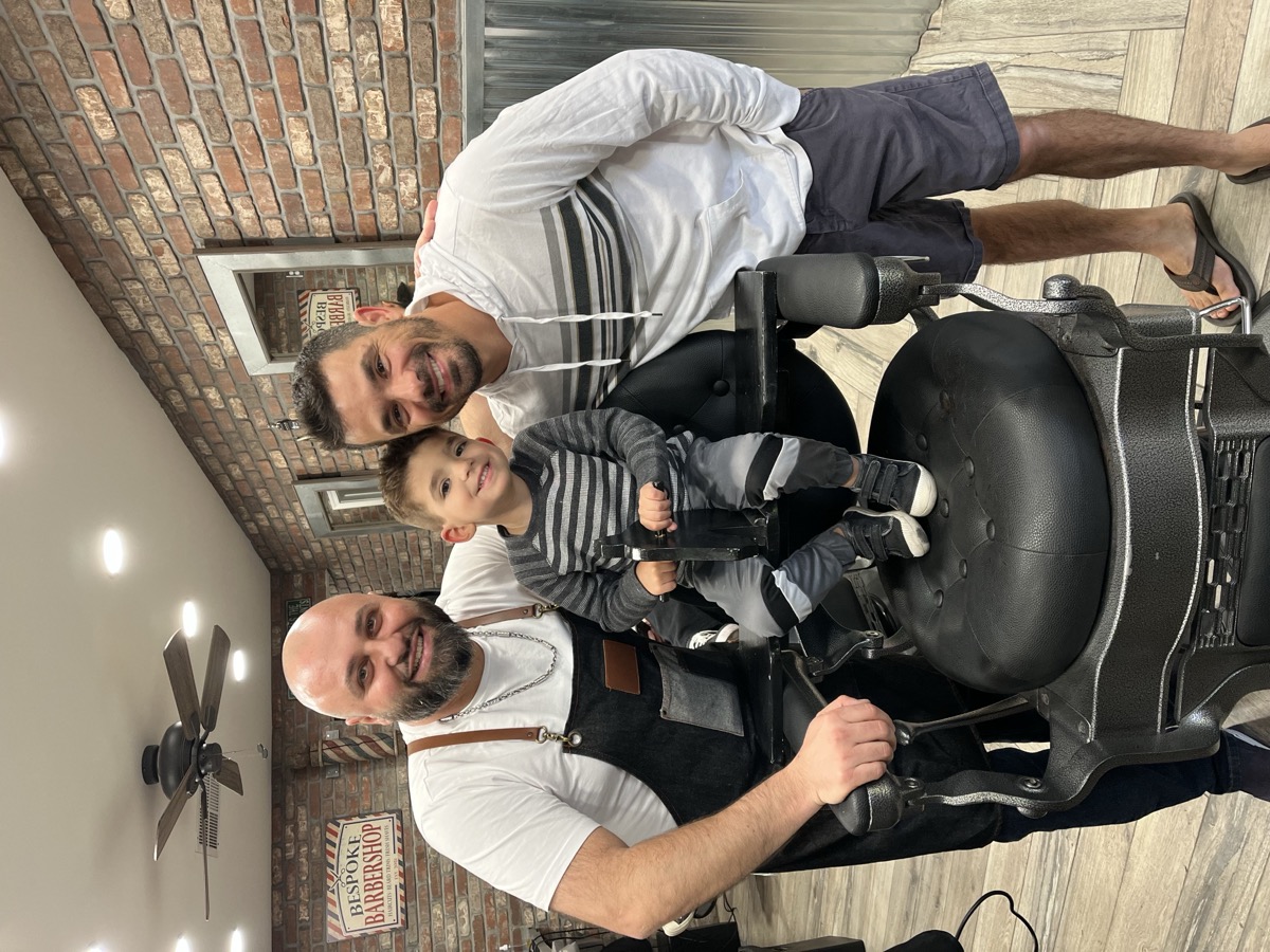 Two men and a young boy at Bespoke Barber — three generations trust Boris