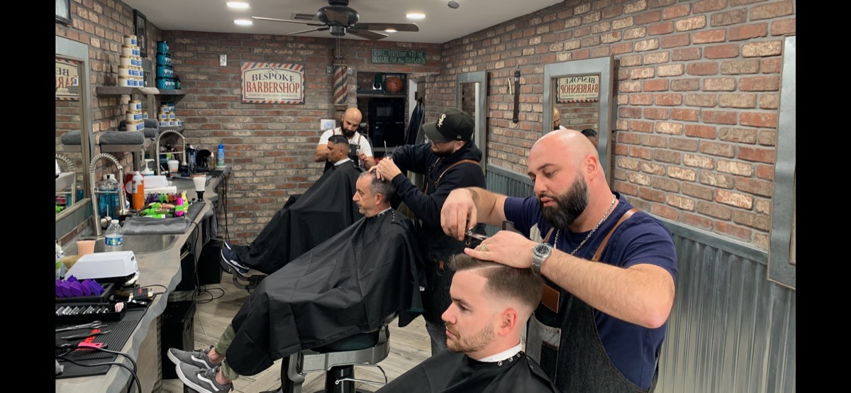 Panoramic view of Bespoke Barber interior with exposed brick and classic chairs