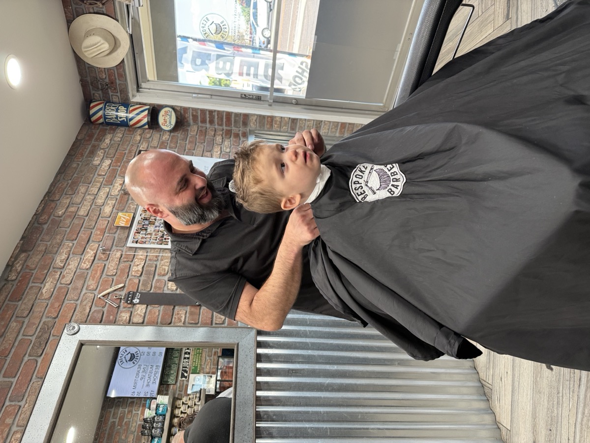 Toddler getting prepped for a haircut at Bespoke Barber